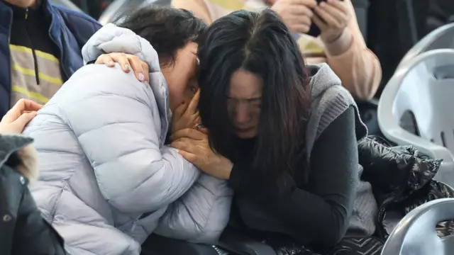 Relatives of passengers of the aircraft that crashed after it went off the runway react outside makeshift shelters at Muan International Airport