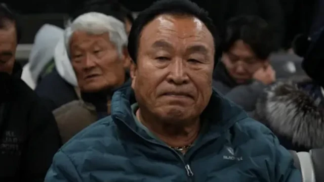 Maeng Gi-Su, a Korean man sits among a crowd of passengers