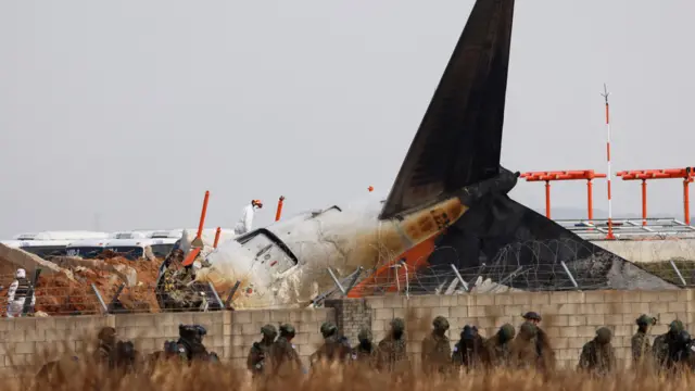 Military personnel work at the site where an aircraft of Jeju Air went off the runway and crashed at Muan International Airport, in Muan, South Korea