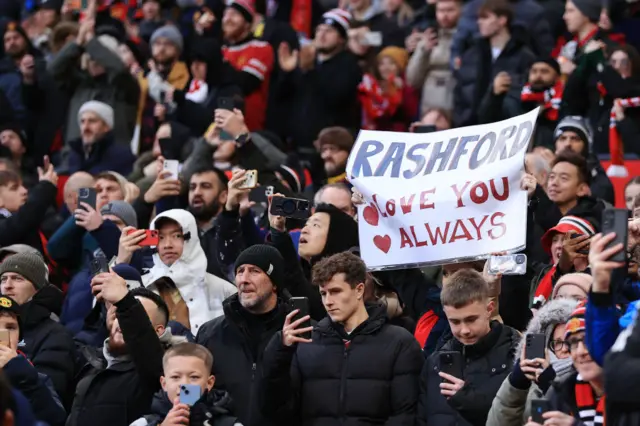 A fan holds up a sign that reads : 'Rashford love you always'