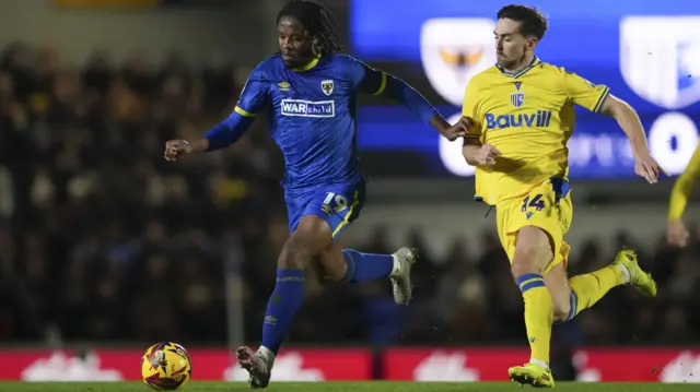 Romaine Sawyers of AFC Wimbledon and Robbie McKenzie of Gillingham