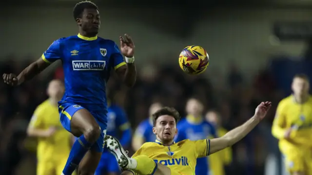 Josh Neufville of AFC Wimbledon and Conor Masterson of Gillingham