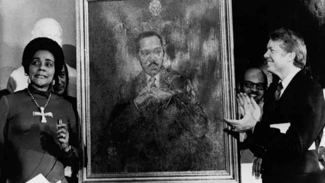 Carter applauds as he looks at a painting of King