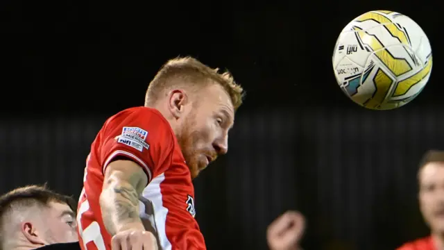 Michael Newberry heads clear for Cliftonville against Crusaders at Solitude