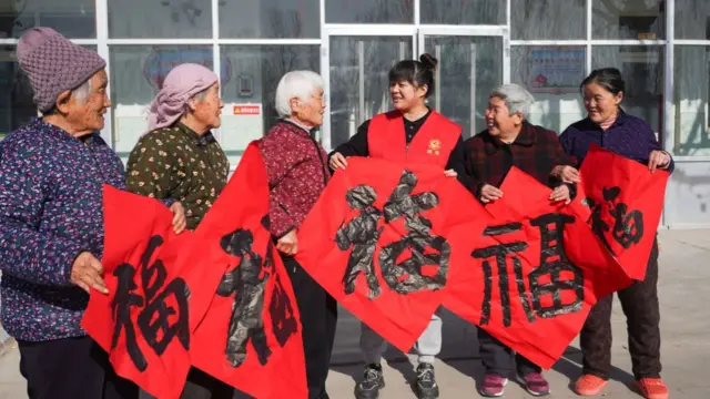 Woman carry red banners with black writing