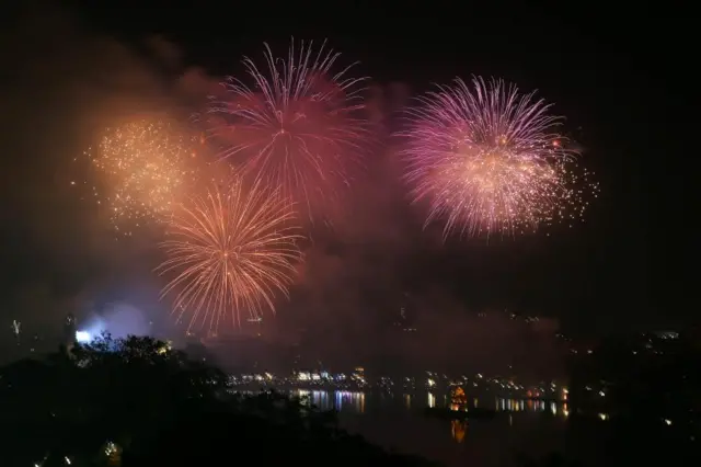 Four big fireworks exploding over a river in the darkness