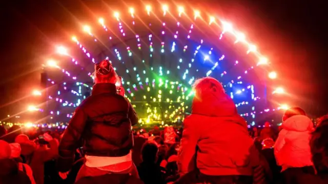 A colourful light display with children watching