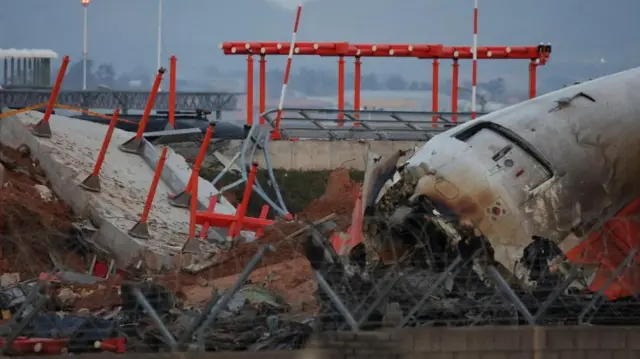 The wreckage of the Jeju Air aircraft that went off the runway and crashed at Muan International Airport lies near a concrete structure it crashed into, in Muan, South Korea, December 30, 2024