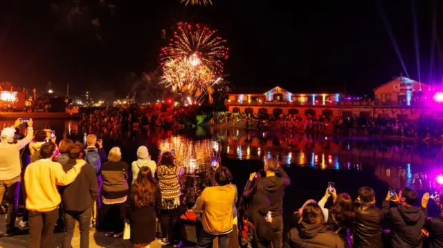 People gather around Whairepo Lagoon for music and fireworks on New Year's Eve in Wellington, New Zealand