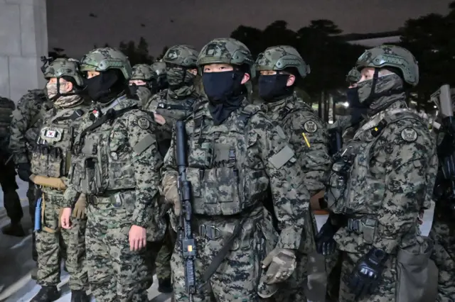 A group of South Korean soldiers holding rifles and wearing face masks