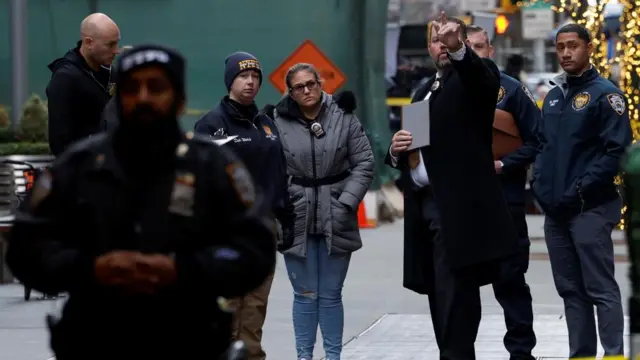 A police officer is pointing ahead, with several others standing next to him