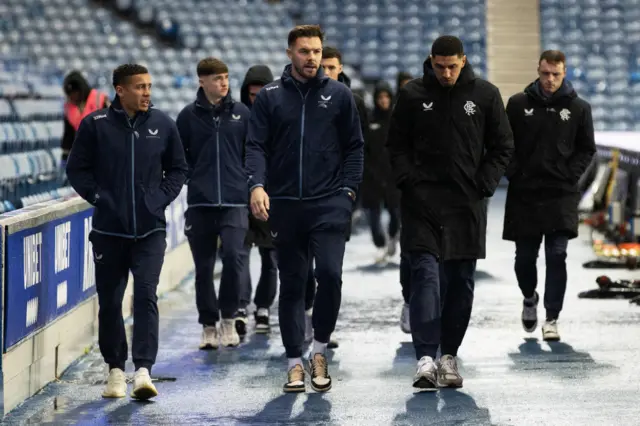 A chilly looking group of Rangers players take a pre-match stroll