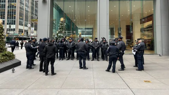 A large group of New York police officers stand in a group outdoors