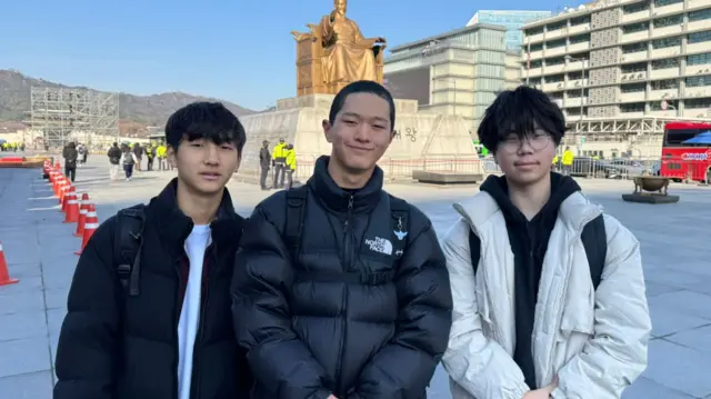 Kwon Ho (middle) pictued with friends at Gwanghwamun, the main square in Seoul