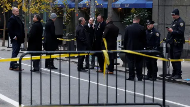 Police gather at the site of the shooting, which has been fenced off.