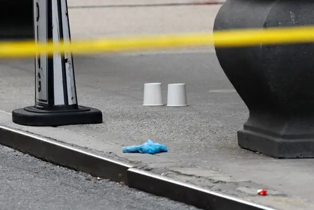 Two cups on the floor marking the location of shell casings found at the scene.