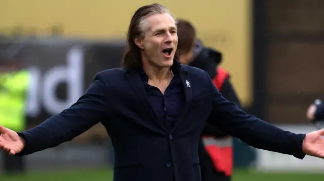 Shrewsbury Town boss Gareth Ainsworth with his hands out wide in victory