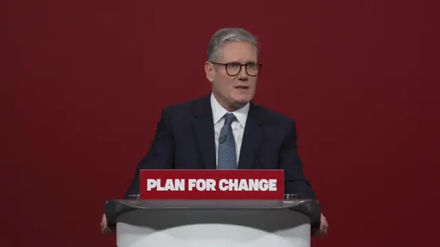 Keir Starmer delivering a speech behind a podium reading 'Plan for Change'