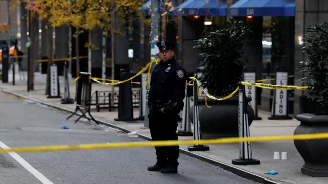 A police officer stands near the scene cordoned by yellow tape.