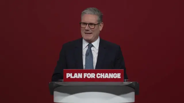 Keir Starmer at a podium with a sign that reads 'Plan for Change'