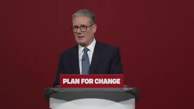 Keir Starmer answers questions from journalists behind a podium