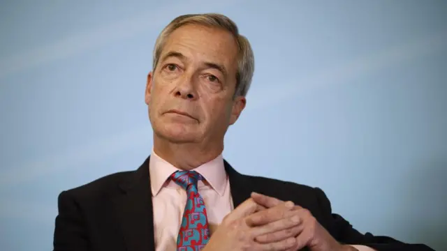 Leader of the Reform UK Party Nigel Farage at press conference wearing a pink shirt and patterned tie