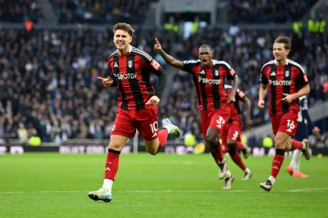 Cairney runs to celebrate his goal at Spurs