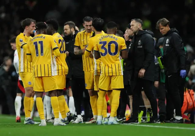 Brighton players chat on the touchline during a stoppage in play