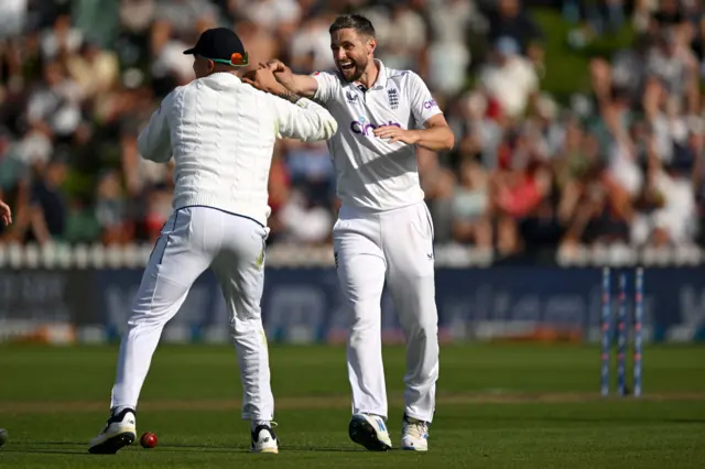 Chris Woakes celebrate the wicket of Rachin Ravindra with Brydon Carse