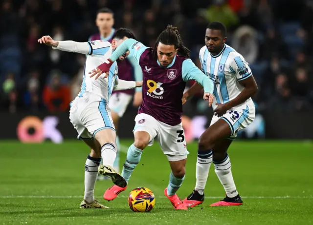 Luca Koleosho of Burnley is put under pressure by Finn Azaz and Anfernee Dijksteel of Middlesbrough