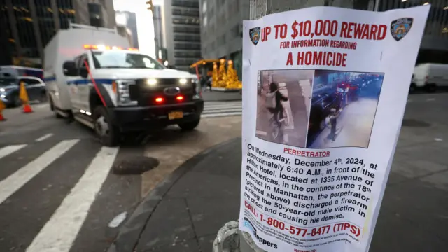 A police poster is attached to a lamp post outside the Hilton hotel near the scene offering a $10,000 reward for information regarding the shooting