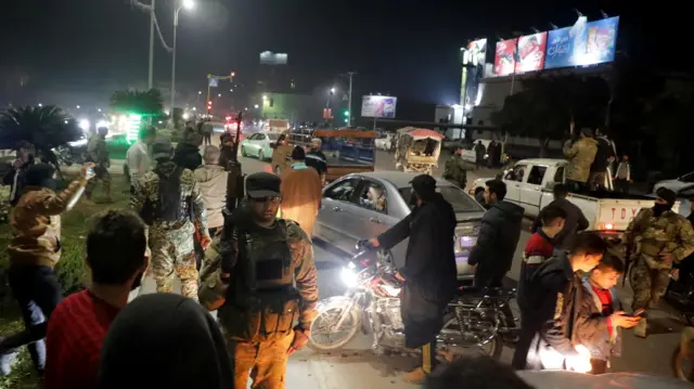 Rebel fighters with weapons gather after Syrian rebels captured the city of Hama