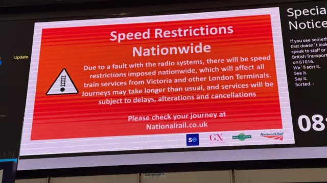 Red digital sign at London Victoria station informing customers of the delays across the rail network.