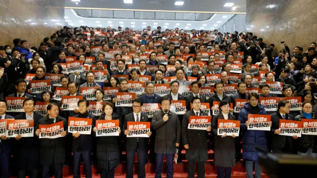 Opposition lawmakers hold banners saying 'Impeach Yoon Suk Yeol!' after the president survived impeachment