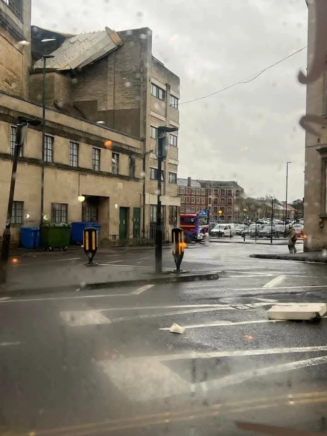 Roof damage to the Quasar building in Bath. There is a fire engine outside the building and a part of roof dangling from the top of the building.