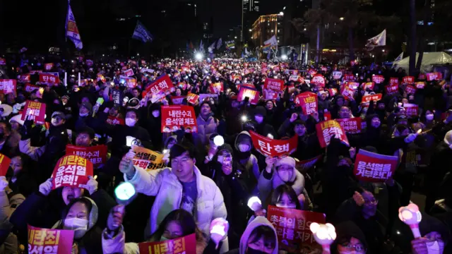 Protesters hold candlelights and placards calling for the impeachment of South Korean President Yoon Suk Yeol during a demonstration in Seoul