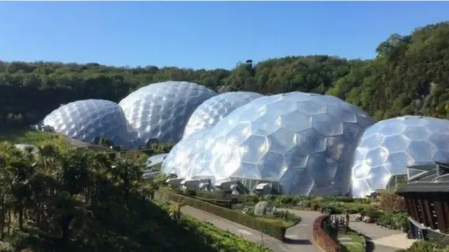 The plastic covered biomes surrounded by gfreen vegetation