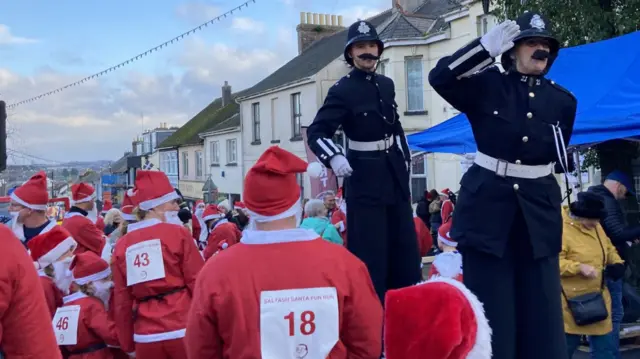 Runners dressed as Santa prepare for their run