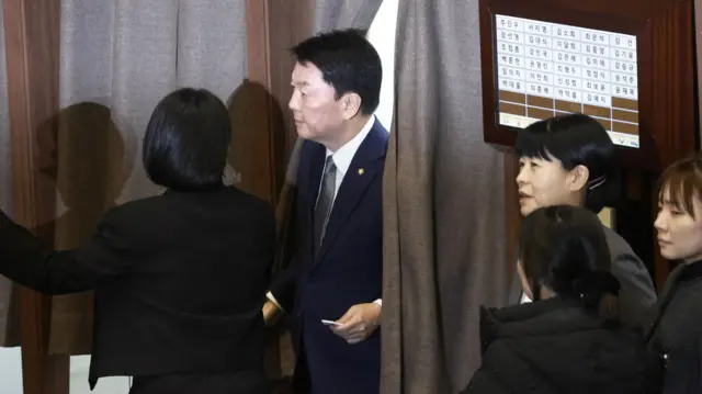 People Power Party (PPP) lawmaker Ahn Cheol-soo (C) walks out of a voting booth after casting his vote on the impeachment motion against President Yoon Suk Yeol at the National Assembly in Seoul, South Korea