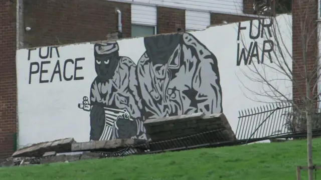 The mural of masked gunmen now only reads 'For Peace For War'