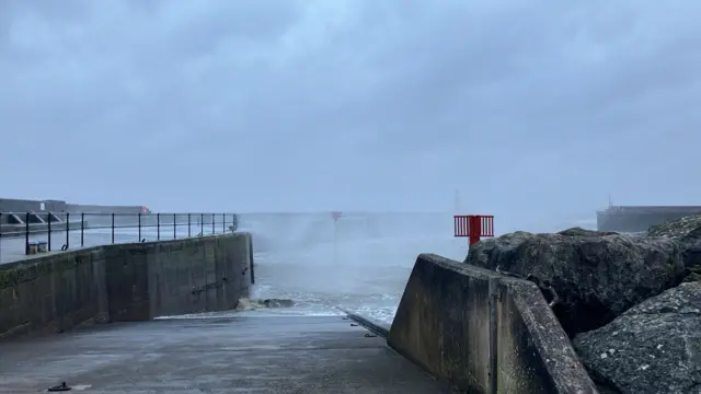 The seafront at Watchet, Somerset. The sea is visible and it is very dark and gray. There is no one around.