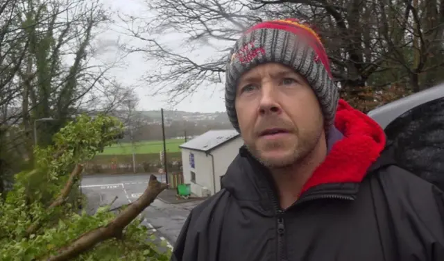 Marc Morris is pictured in front of downed trees in Llangunnor, Carmarthenshire