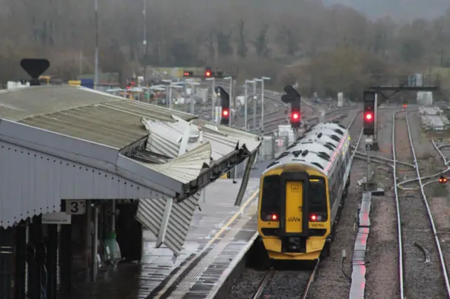 a GWR train at Westbury Station. A damaged canopy overhanging the platform can be seen.