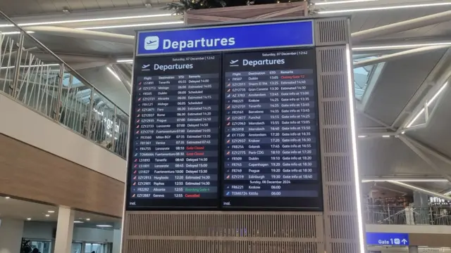 A departures board at Bristol Airport showing a variety of delayed and cancelled flights.