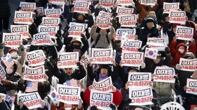 Yoon supporters hold placards calling for the arrest of opposition leader Lee Jae-myung