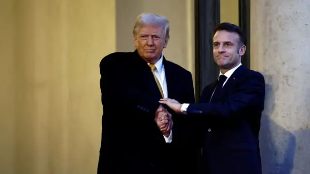 Emmanuel Macron shakes hands with Donald Trump as he welcomes him to the Elysee Palace ahead of Notre-Dame's reopening this evening