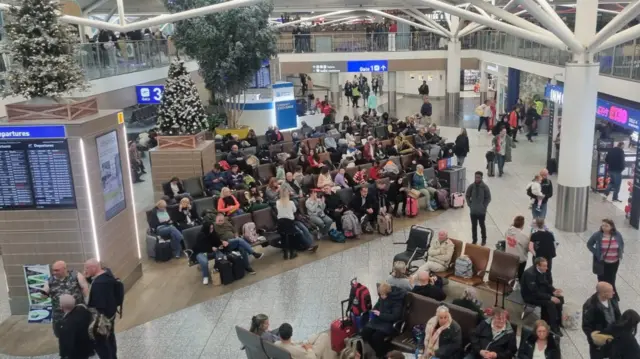 A gathering of people in the departures lobby at Bristol Airport