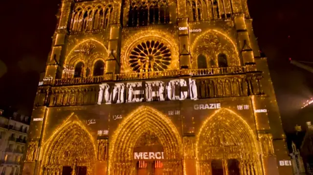 Notre-Dame lit up with the word Merci