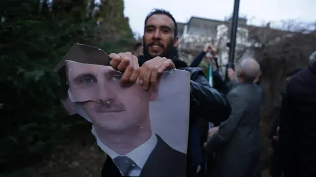 A supporter of the Syrian opposition residing in Serbia tears a portrait of Bashar al-Asa