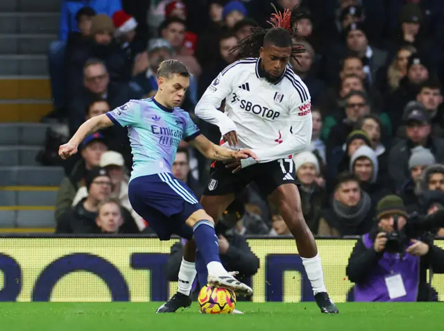 Arsenal's Leandro Trossard in action with Fulham's Alex Iwobi.